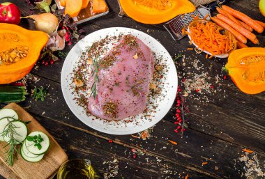 Çiğ hindi göğsü, sebze ve baharatlar ahşap bir masa üzerinde. 