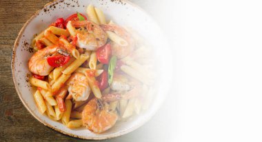 Penne makarna karides ve rustik ahşap masa üzerinde domates ile. 