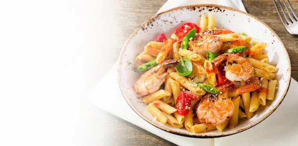 Penne pasta with shrimp, tomatoes and herbs on wooden background — Stock Photo, Image