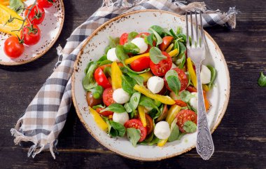 Rustik ahşap bir masa üzerinde mozzarella salatası. 