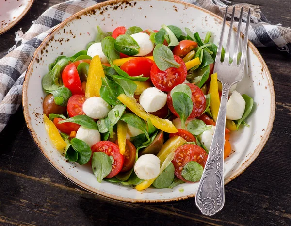 Taze bir rustik ahşap masa üzerinde mozzarella salatası.