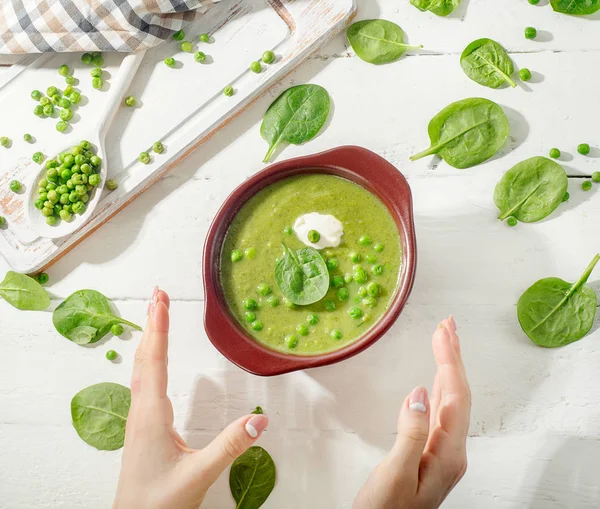 Mujer manos con tazón de sopa de guisantes . — Foto de Stock