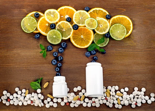 Fresh citrus fruits and pills — Stock Photo, Image