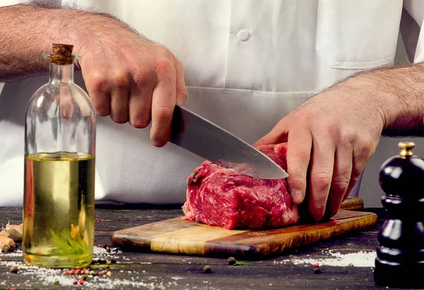 Carnicero cortando carne cruda —  Fotos de Stock