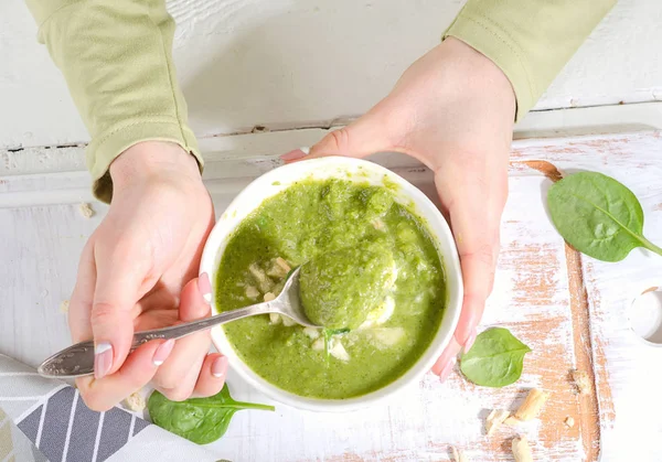 Mani che tengono ciotola di zuppa di spinaci — Foto Stock