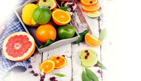 Fresh citrus fruits with cutting board — Stock Photo, Image