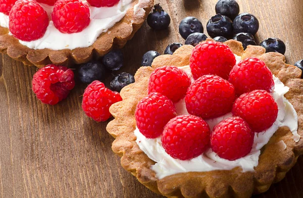 Torten mit Beeren auf Holztisch — Stockfoto