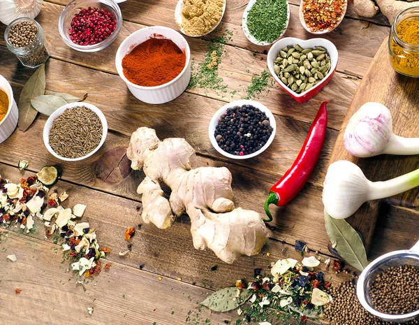 Kleurrijke specerijen en verse kruiden op houten tafel — Stockfoto