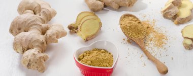 Zencefil kökü ve ahşap masa üzerinde toz 