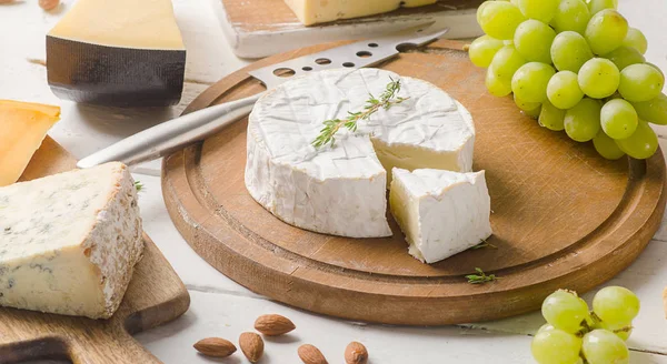 Сыр на белом деревянном столе — стоковое фото