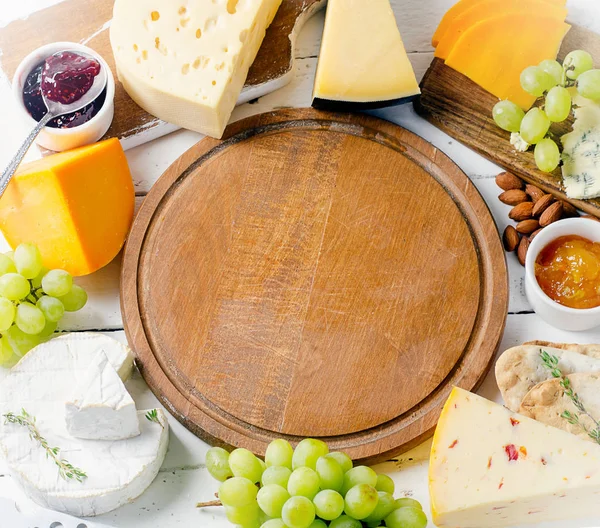 Assorted cheeses served with grapes — Stock Photo, Image