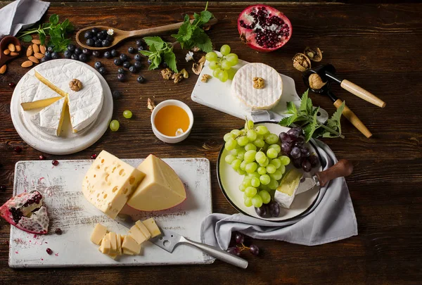 Сыр с виноградом на деревянном столе . — стоковое фото