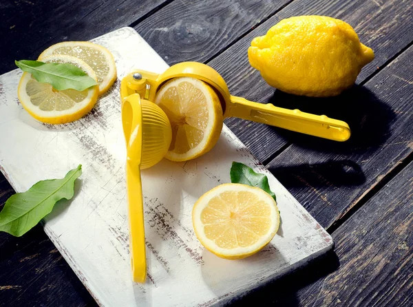 Squeezer and lemons on board — Stock Photo, Image