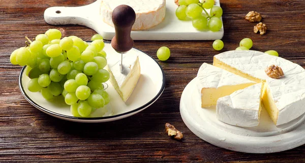 Brie on  dark wooden board — Stock Photo, Image