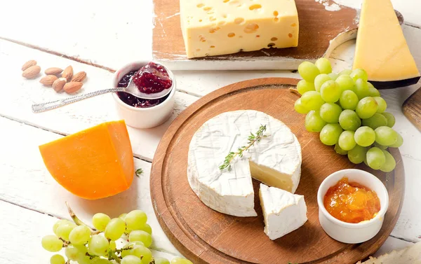 Different kinds of cheeses with grapes — Stock Photo, Image