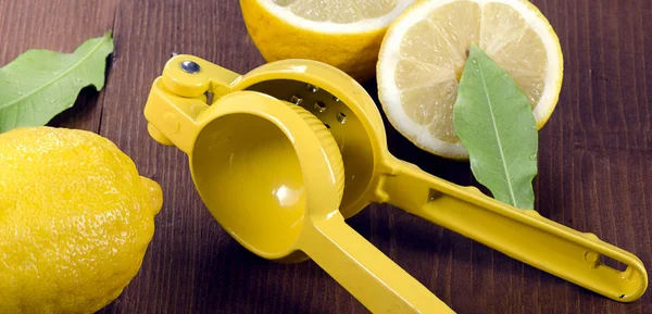 Squeezer and lemons on board — Stock Photo, Image