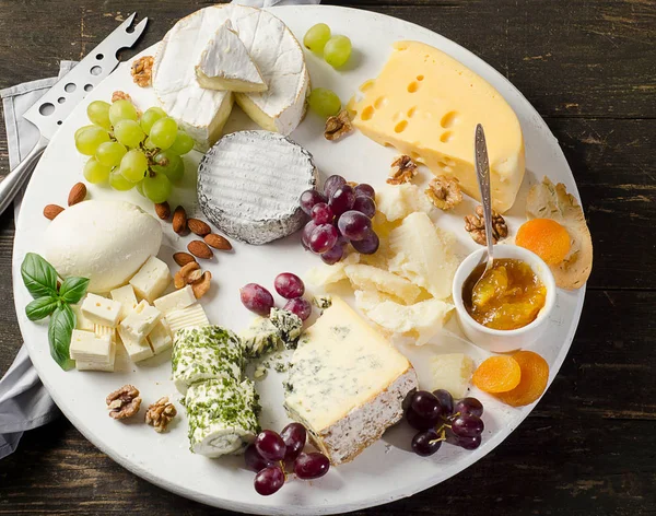 Delicious cheeses on a wooden table. — Stock Photo, Image