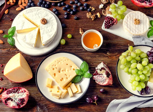 Cheeses with grapes  on  board — Stock Photo, Image