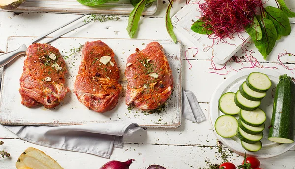 Marinated steaks on cutting board — Stock Photo, Image