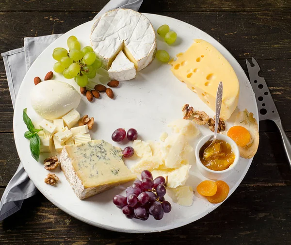 Delicious cheeses on a wooden table. — Stock Photo, Image