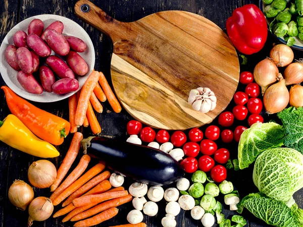 Biologische groenten op donkere houten bord. — Stockfoto