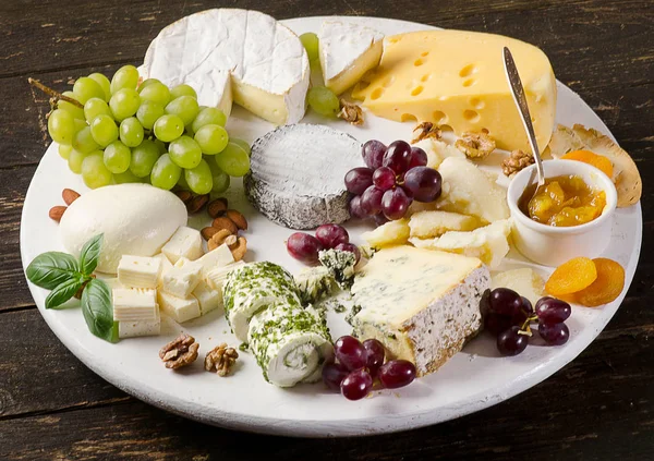 Pratos de queijo servidos com uvas, compotas e nozes — Fotografia de Stock