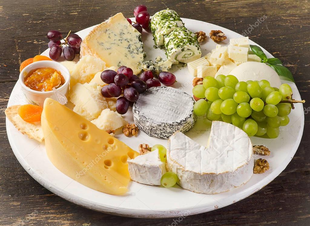 Käseplatte mit Trauben, Marmelade und Nüssen serviert — Stockfoto
