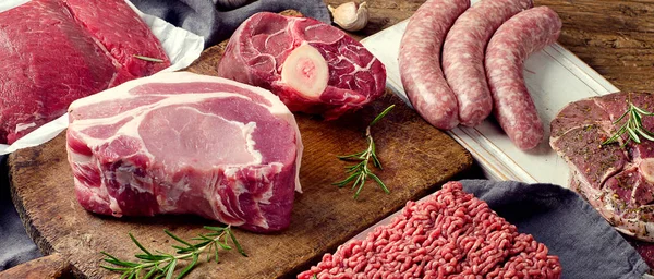 Diversi tipi di carne fresca cruda su sfondo di legno scuro . — Foto Stock