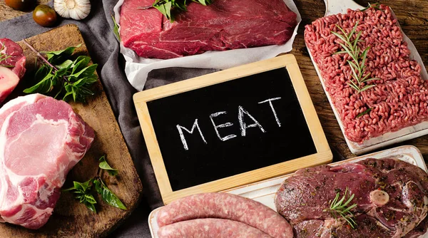 Ahşap arka plan üzerinde taze çiğ et farklı türleri. 