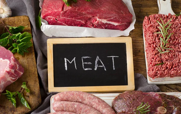 Koyu ahşap zemin üzerine taze çiğ et farklı türleri. 