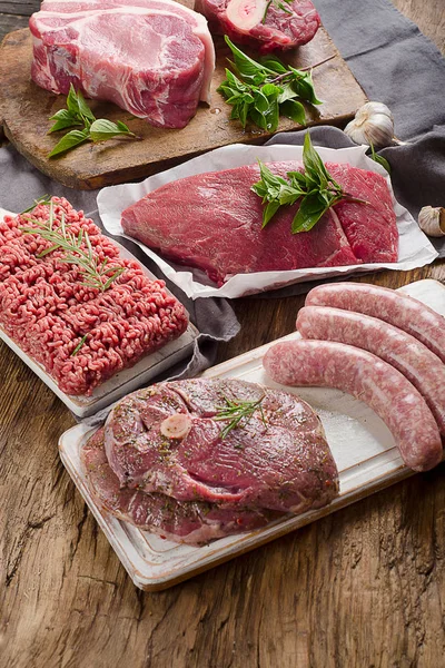 Koyu ahşap zemin üzerine taze çiğ et farklı türleri. 