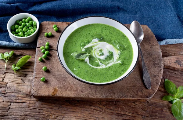 Ahşap kesme tahtası üzerinde yeşil bezelye çorbası. Üstten Görünüm