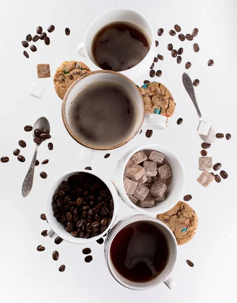 Flying coffee cups with coffee beans — Stock Photo, Image