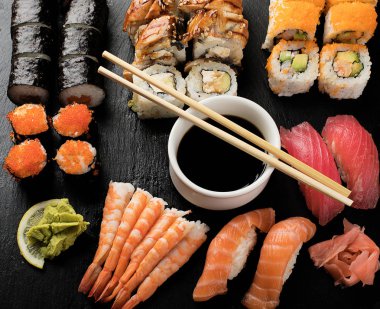 Üstten Görünüm suşi nigiri ayarla, suşi rulo ve sashimi wasabi, dilim limon, soya sosu ve ahşap sopa ile masaya servis 