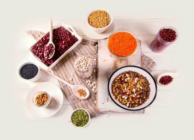 Farklı baklagiller seramik eşya, vejetaryen ve vegan gıda kavanozlara üstten görünüm Beyaz ahşap zemin üzerinde