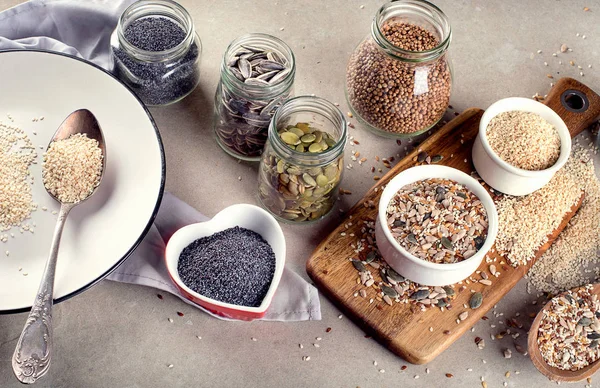 Bovenaanzicht Van Verschillende Zaden Witte Plaat Houten Snijplank Vegetarische Veganistische — Stockfoto