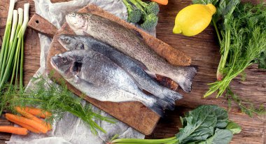 Taze balık ve o ahşap arka plan yemek pişirmek için malzemeler. Üstten Görünüm.