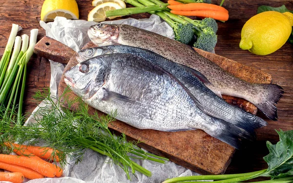 新鲜的鱼和烹调的配料 木质背景 顶部视图 — 图库照片