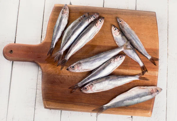 Fresh sprat fish on a white wooden background. Top view — Stock Image Fresh Sprat Fish White Wooden Background Top View Royalty Free Stock Images