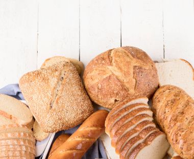 Beyaz ahşap masa arka plan üzerinde karışık ekmek. Üstten Görünüm 