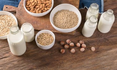 Süt alternatif türleri. Vegan gıda kavramı. Sigara süt süt ahşap arka plan üzerinde 