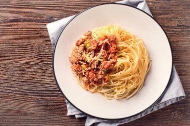 Spagetti bolognese ahşap arka plan üzerinde beyaz tabak içinde. İtalyan sağlıklı gıda. Üstten Görünüm.