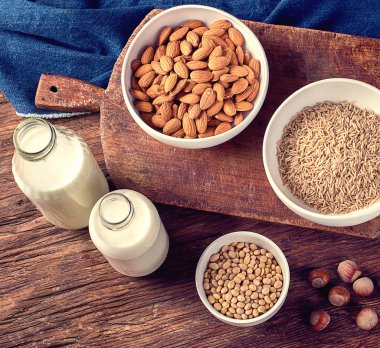 Süt alternatif türleri. Vegan gıda kavramı. Sigara süt süt ahşap arka plan üzerinde 