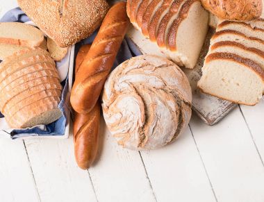 Beyaz ahşap masa arka plan üzerinde karışık ekmek. Üstten Görünüm 