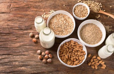 Süt alternatif türleri. Vegan gıda kavramı. Sigara süt süt ahşap arka plan üzerinde 