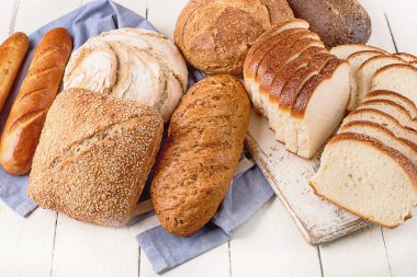 Beyaz ahşap masa arka plan üzerinde karışık ekmek. Üstten Görünüm 