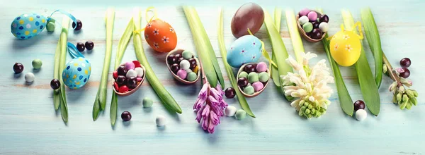 Frühlingsblumen Mit Ostereiern Auf Blauem Holzgrund — Stockfoto