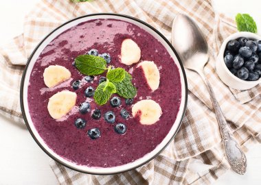 Sağlıklı kahvaltı için taze yaban mersini ile güler yüzlü kase. Top vie