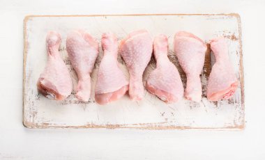 Beyaz ahşap kesme tahtası üzerinde çiğ tavuk budu. Üstten Görünüm. Sağlıklı beslenme