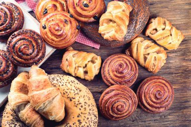 Ekmek, çörek, ay çöreği. Fırın malzemeleri ahşap arka plan üzerinde. Kahvaltı gıda kavramı. Üstten Görünüm 